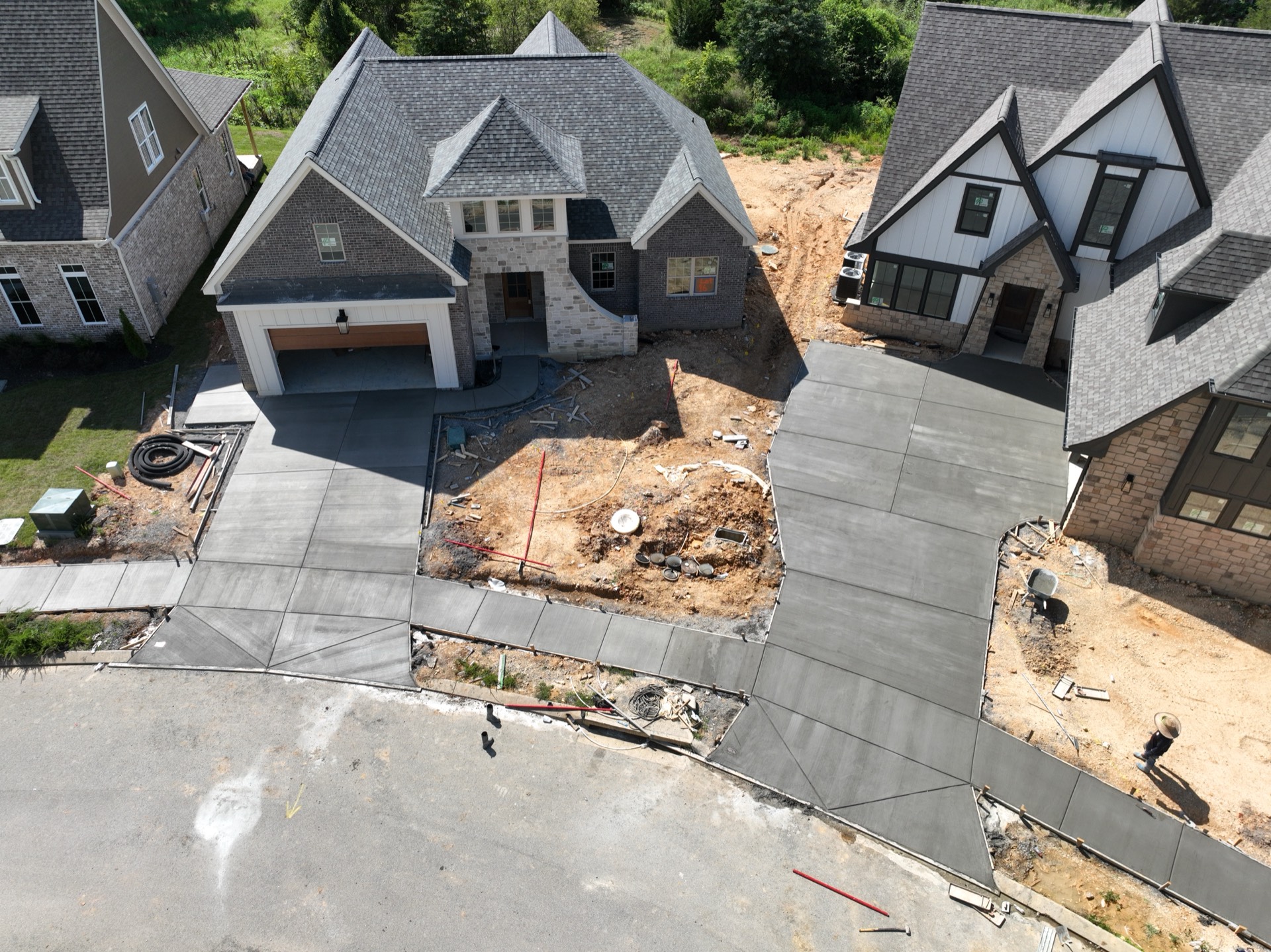 Aerial view of fresh concrete driveways at two new-construction homes