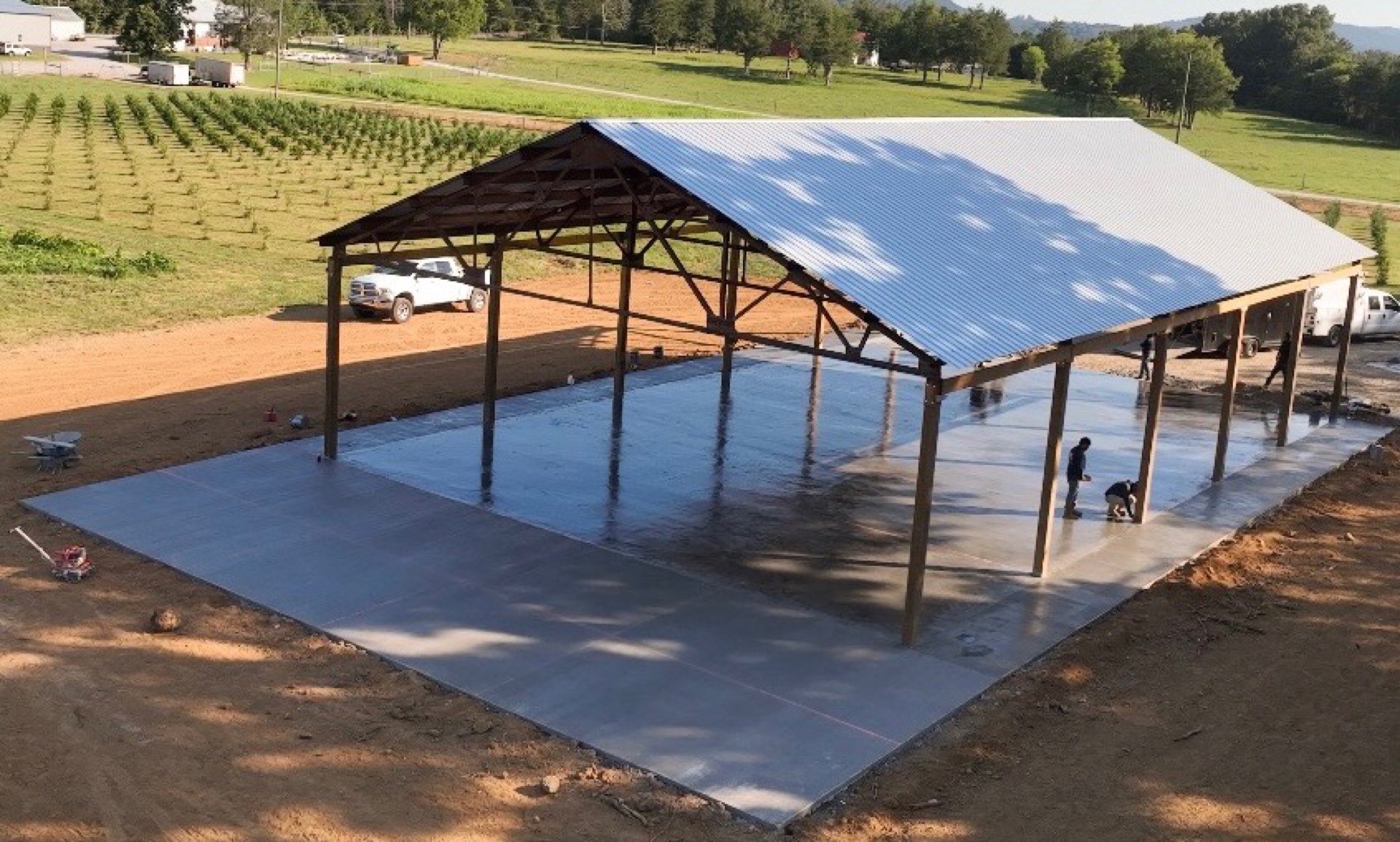 Broom-finished concrete slab poured under a timber-frame pavilion