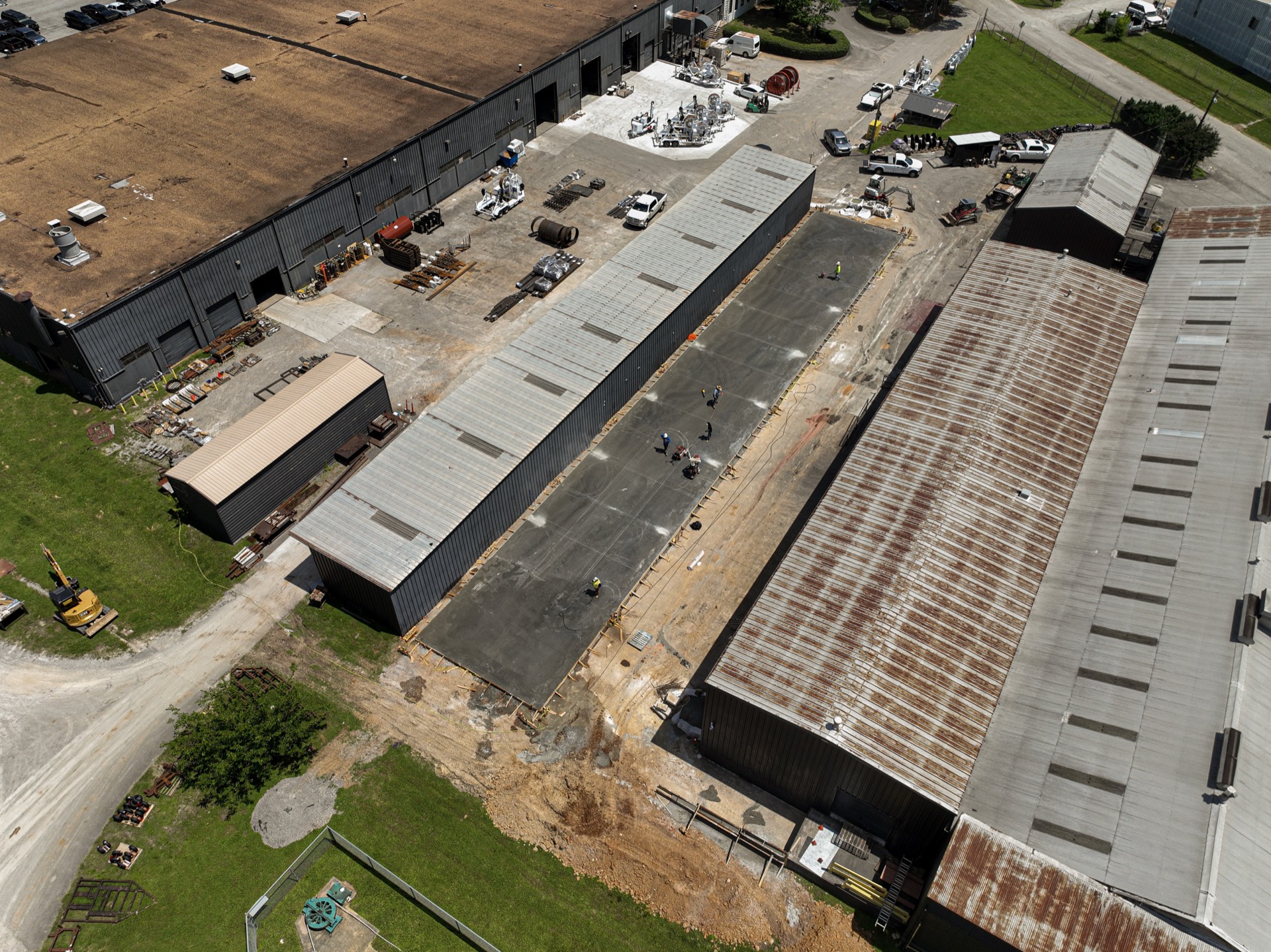 Aerial view of a large commercial concrete slab poured between warehouse buildings